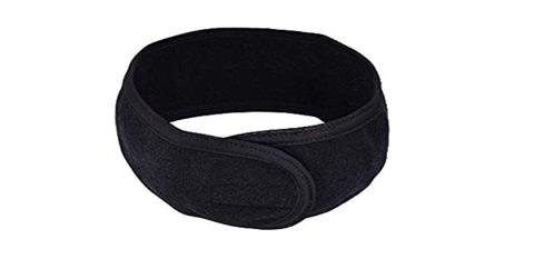 Zwarte terry bandeau met klittenbandsluiting, opgerold gepresenteerd, voor gebruik in schoonheidssalons.